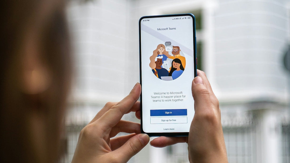 Zwei Hände halten ein Smartphone, das Microsoft Teams darstellt.