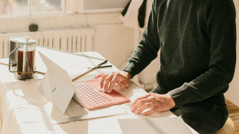 Ein Mann nutzt einen Laptop an einem Schreibtisch.