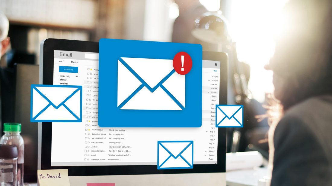 Ein Bildschirm auf einem Schreibtisch und E-Mail-Symbole.
